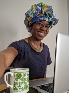 Krystal sits at her desk with her laptop and a Japanese teacup with green flowers